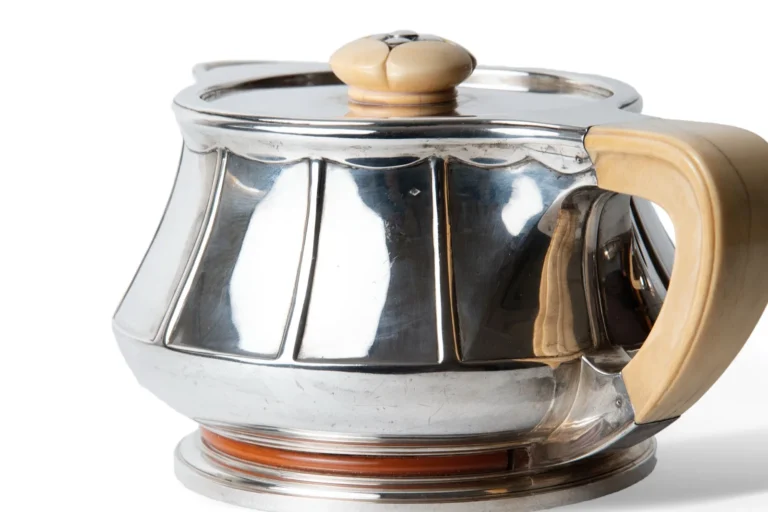 Four-piece service with ivorine handles and orange enamelled interiors.
