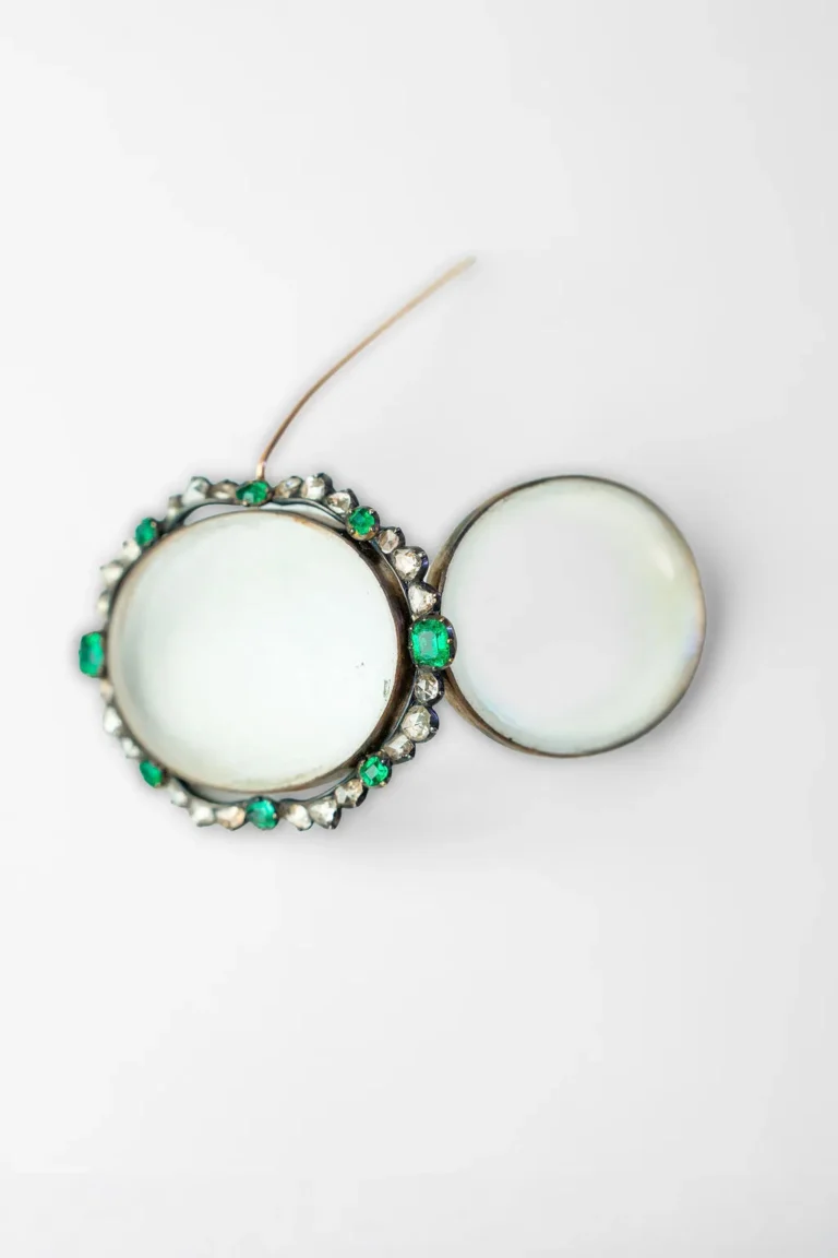 Folding lenses with an emerald and diamond mounted rim.