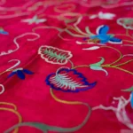 Deep red silk with a central medallion and multicoloured fringe.