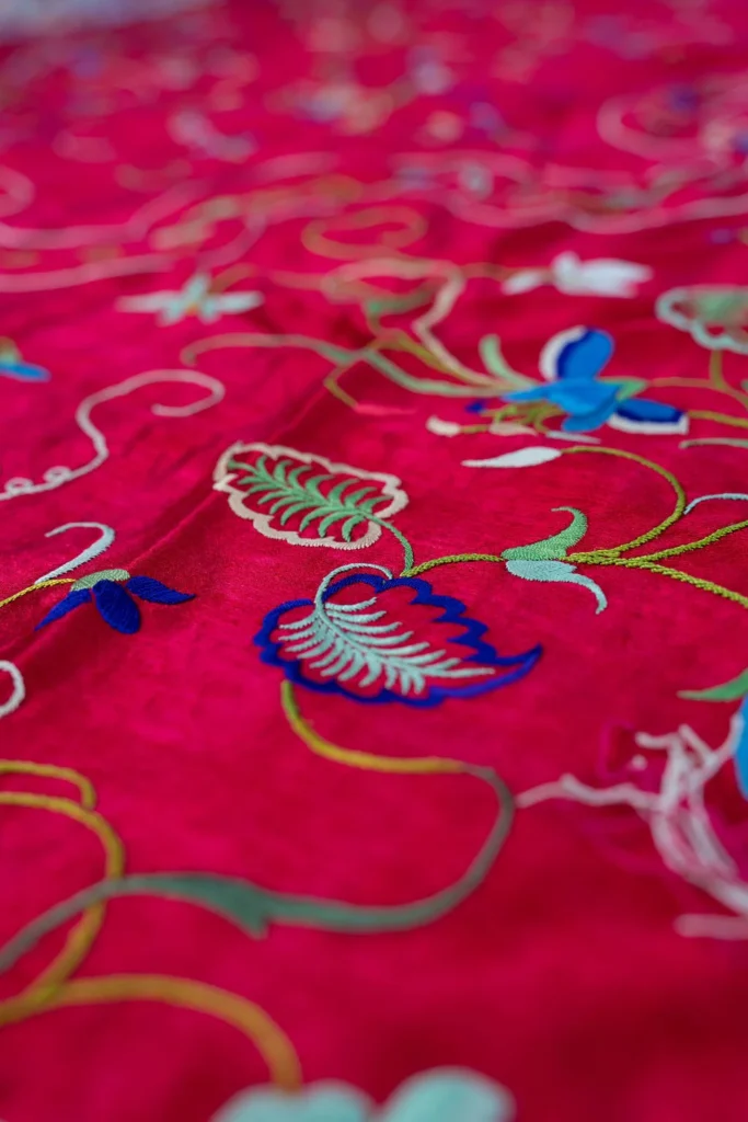 Deep red silk with a central medallion and multicoloured fringe.