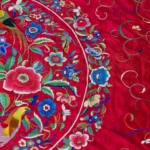 Deep red silk with a central medallion and multicoloured fringe.