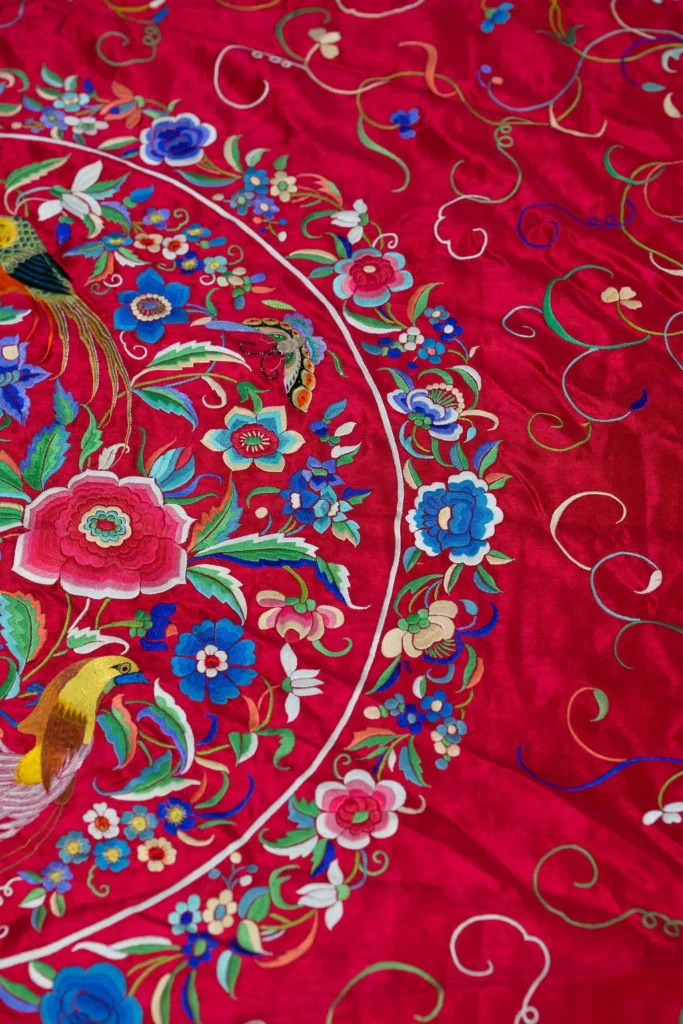Deep red silk with a central medallion and multicoloured fringe.