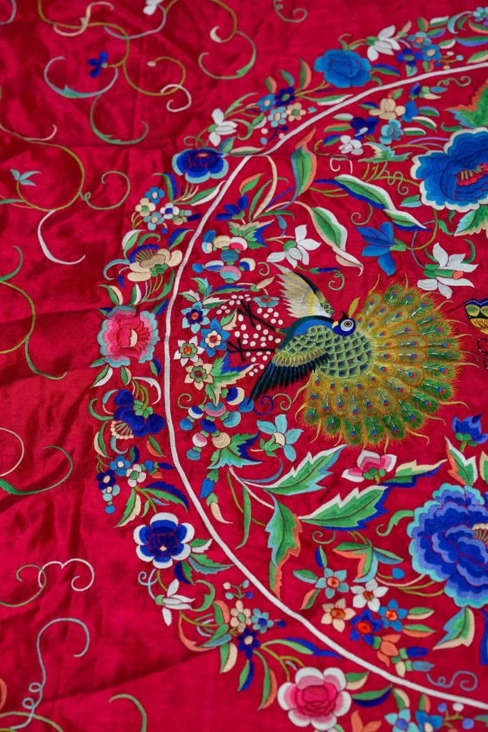 Deep red silk with a central medallion and multicoloured fringe.
