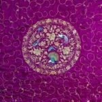 Violet silk embroidered in silver thread with birds and flowers.
