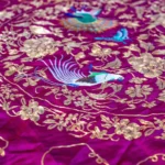 Violet silk embroidered in silver thread with birds and flowers.