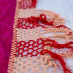 Magenta silk with white and silver floral work and a long fringe.