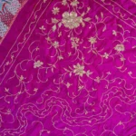 Magenta silk with white and silver floral work and a long fringe.