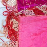 Magenta silk with white and silver floral work and a long fringe.